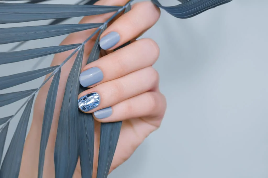 Manucure avec un vernis bleu doux